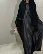 Load image into Gallery viewer, Back view of elegant black closed satin abaya with subtle shine