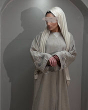 Load image into Gallery viewer, Model wearing elegant beige abaya with handmade embellishments on sleeves
