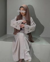 Load image into Gallery viewer, Model in nude pink linen abaya highlighting handmade sleeve decoration