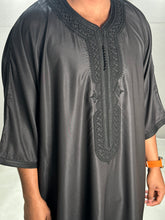 Load image into Gallery viewer, Folded Moroccan black thobe showcasing fine fabric and stitching
