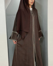 Load image into Gallery viewer, Model dressed in chocolate linen abaya featuring embroidery and open sleeves
